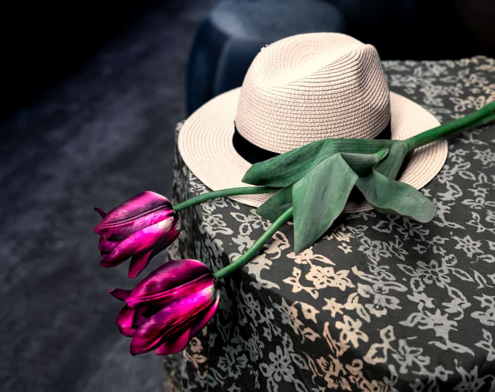 Chupalla hat and roses on top of a table.