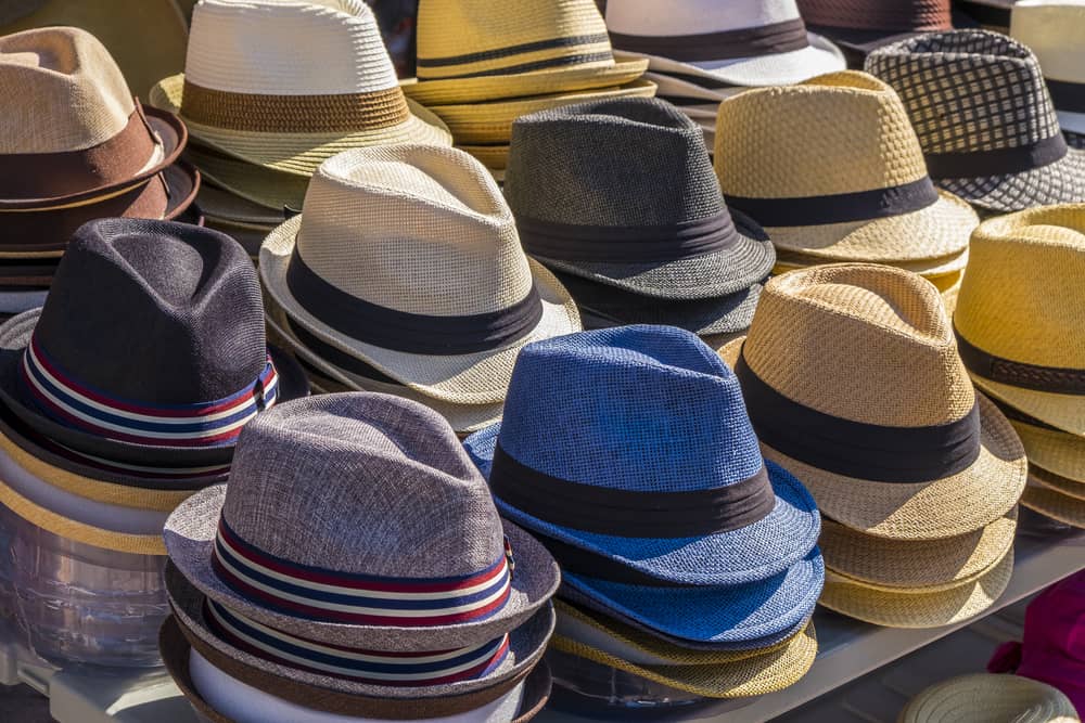 This is a close look at different fedoras on display at a market.