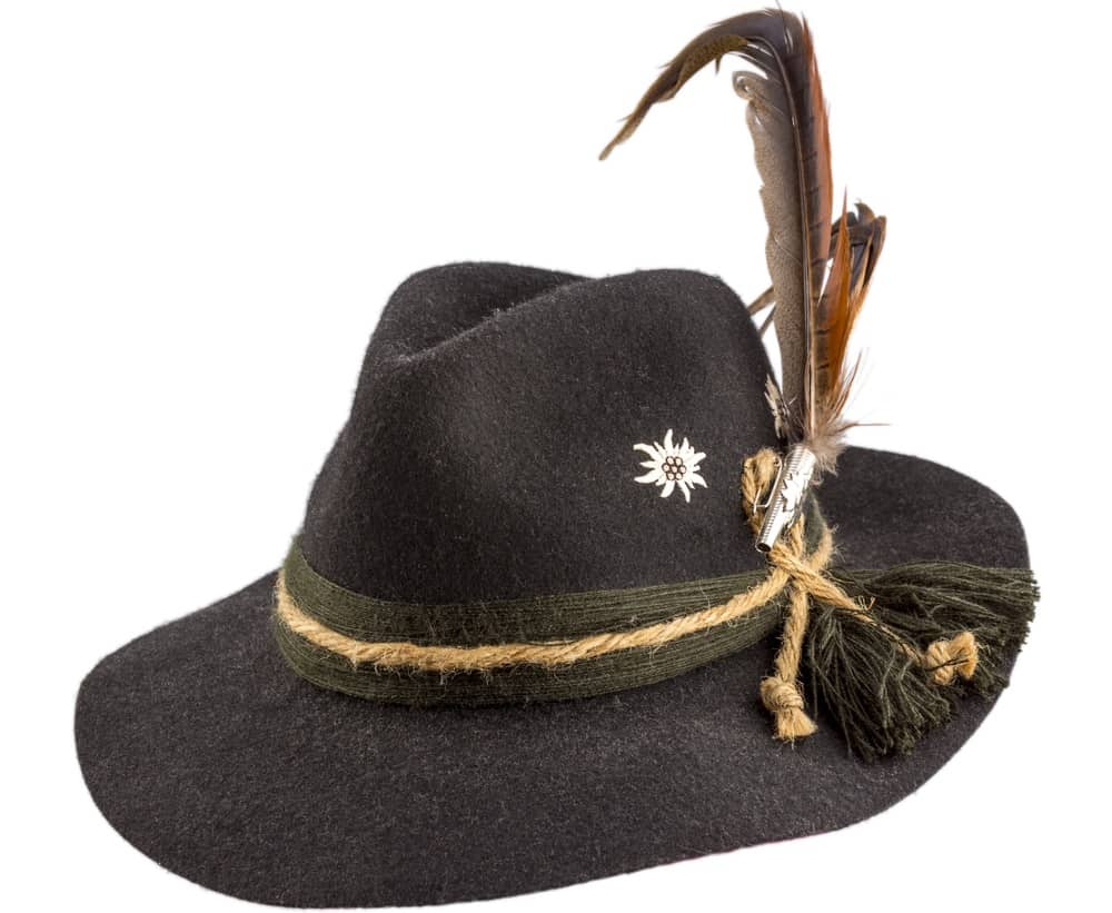This is a close look at a tyrolean hat that has yarn bands and feathers.