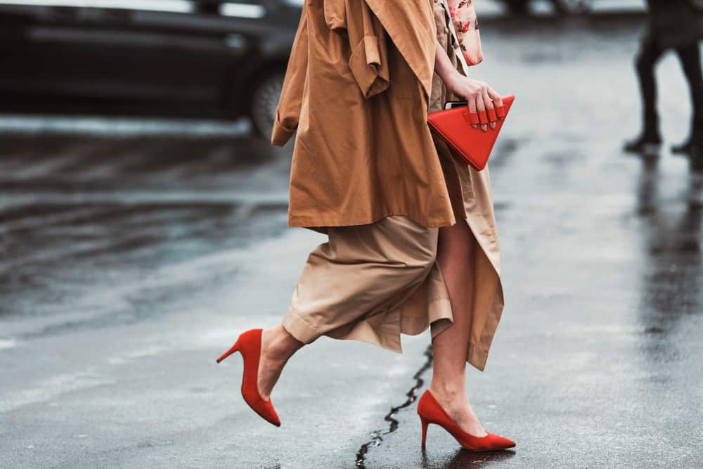 This is a close look at a woman wearing a pair of red pointy heels with her maxi skirt.