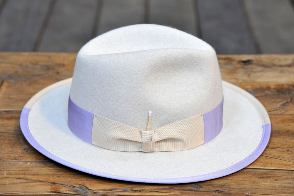 This is a borsalino hat on a table with purple accents.
