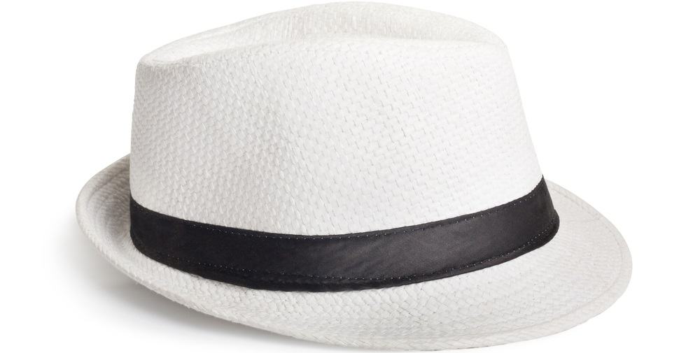 A close look at a white woven fedora hat with a black band.