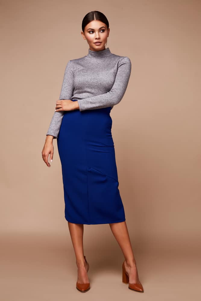 This is a woman wearing a long-sleeve gray shirt and a blue long skirt.