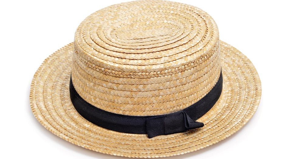 A close look at a straw boater hat that has a thin black band.