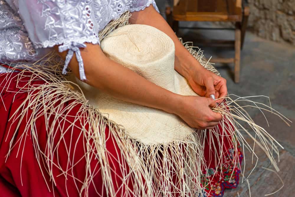 A close look at a woman weaving a Panama hat.