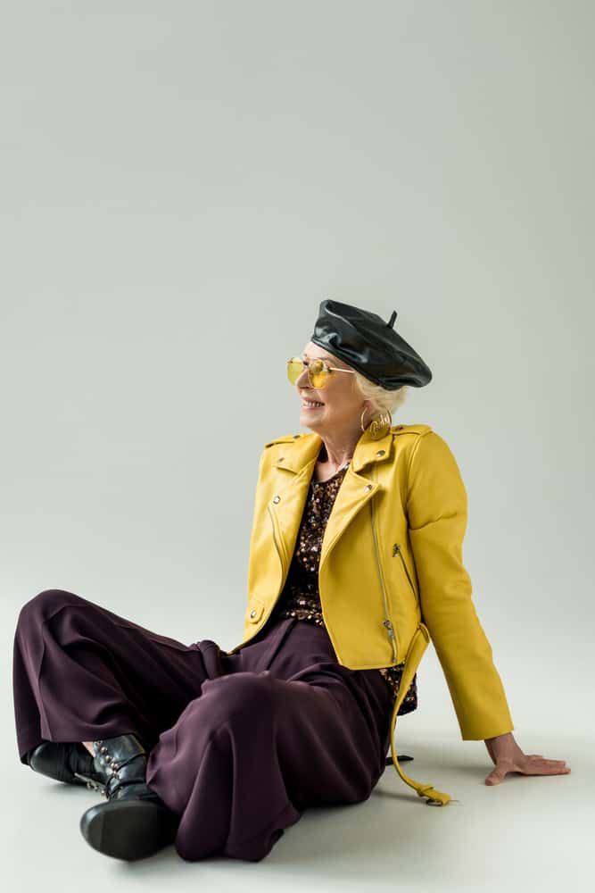 This is a woman wearing a black leather beret with her yellow leather jacket.