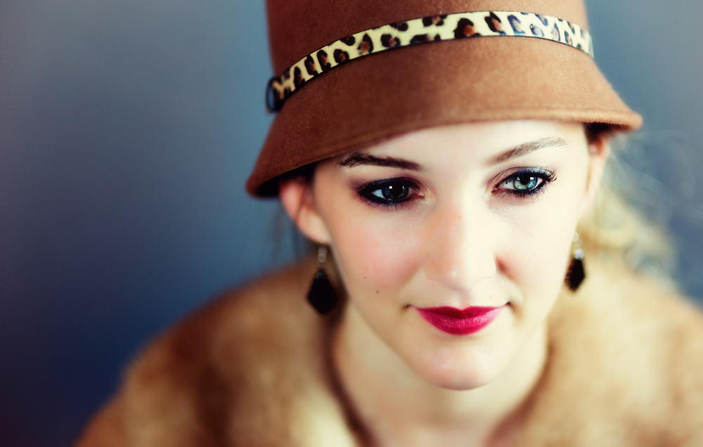 This is a close look at a woman wearing a vintage brown cloche hat.