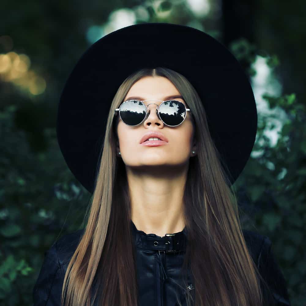 This is a long-haired woman wearing a wide-brimmed hat and black leather jacket.