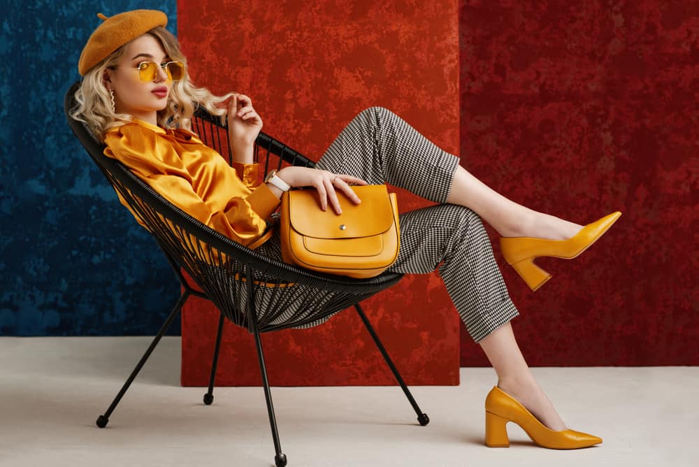 This is a fashionable woman wearing matching mustard blouse, shoes and beret.
