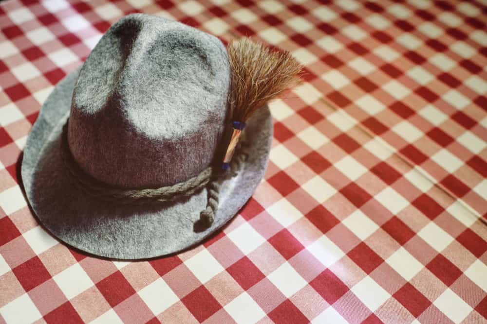 This is a close look at a gray traditional Bavarian hat on a picnic cloth.